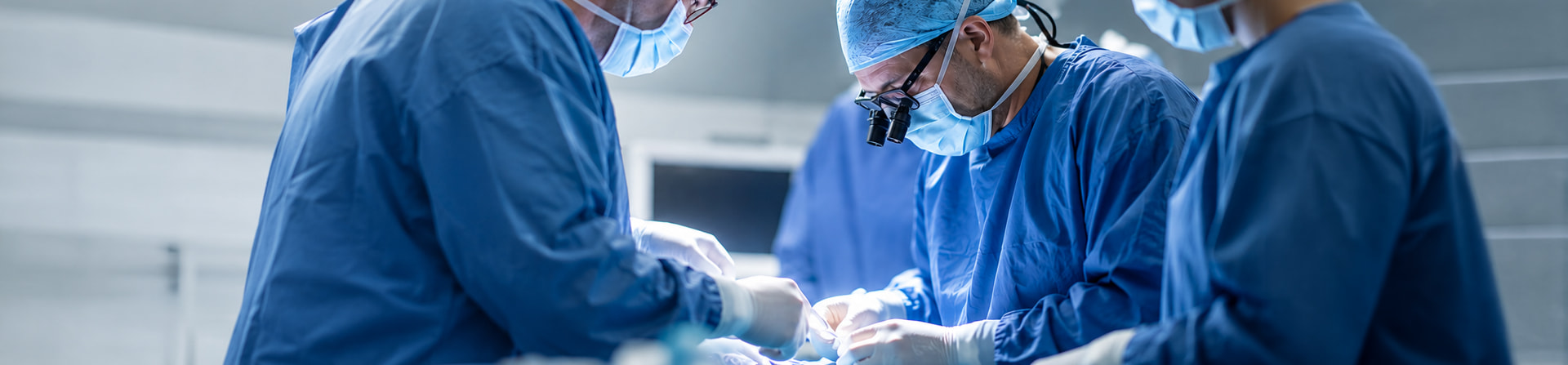 A surgical team in scrubs and masks working together during an operation