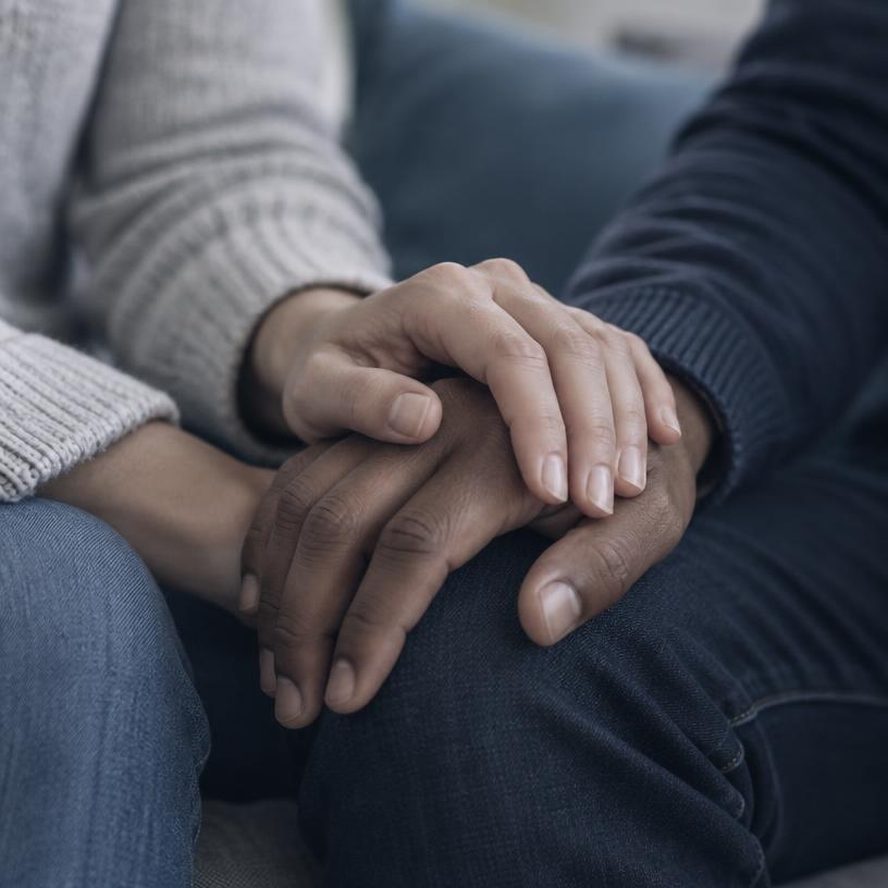 Supportive companion holding another person's hand